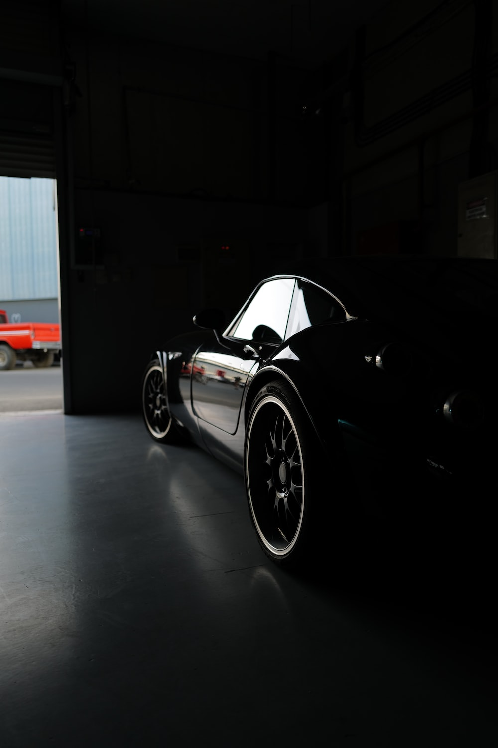 Light reflecting off a black car in a garage